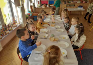 Dzieci spożywają śniadanie wielkanocne