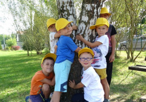Dzieci przytulają się do drzewa