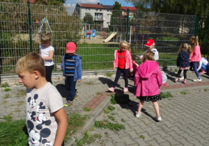 Dzieci sprzątają teren dookoła przedszkola