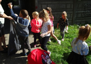 Dzieci sprzątają teren dookoła przedszkola
