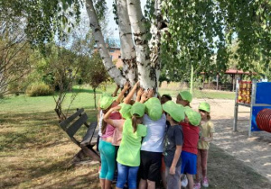 Dzieci przytulają się do drzew