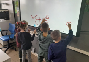Dzieci korzystają z tablicy interaktywnej