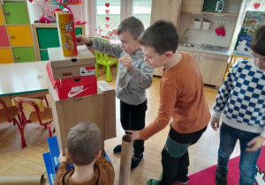Dzieci wykonują rakiety z pudelek