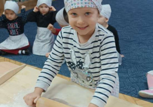 Dzieci wałkują ciasto na pierniczki