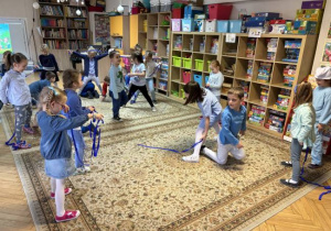 Dzieci uczestniczą w smerfowych zabawach muzyczzno-ruchowych