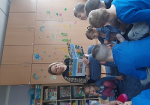 Dzieci słuchają ciekawostek zawartych w książce „Dbam o środowisko”.