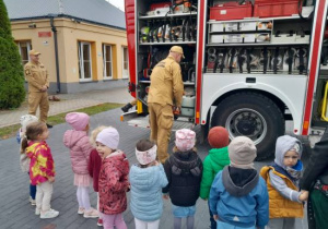 Dzieci oglądają wyposażenie wozu strażackiego.