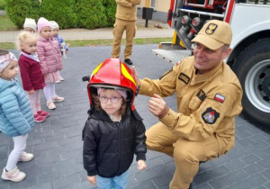 Dzieci oglądają wyposażenie wozu strażackiego.