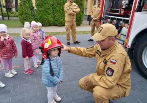 Dzieci oglądają wyposażenie wozu strażackiego.