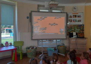 Dzieci oglądają film edukacyjny o nietoperzach.