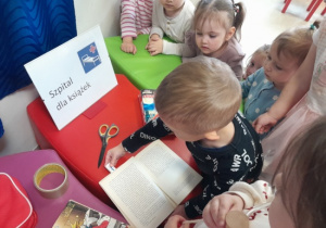 Dzieci uczą się naprawiać zniszczone książki.