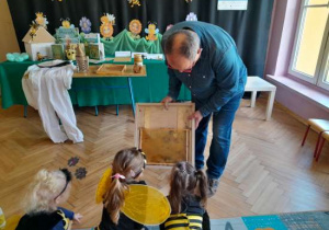 Dzieci uczestniczą w spotkaniu z pszczelarzem.