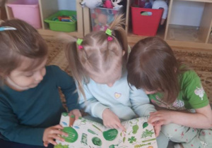 "Kajtusie" oglądają książkę pt. "Wielka księga kolorów. Zabawna przygoda w krainie barw".