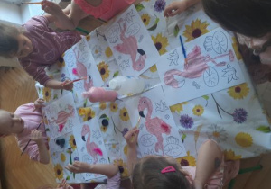 "Kajtusie" malują farbami flamingi.