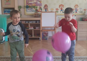 "Kajtusie" bawią się balonem-piłką do odbijania.