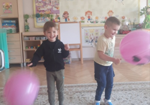 "Kajtusie" bawią się balonem-piłką do odbijania.