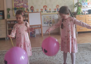 "Kajtusie" bawią się balonem-piłką do odbijania.