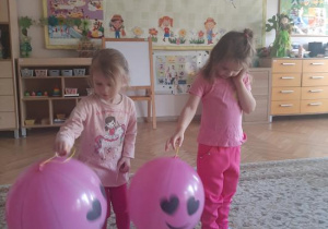 "Kajtusie" bawią się balonem-piłką do odbijania.