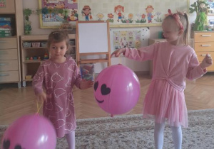 "Kajtusie" bawią się balonem-piłką do odbijania.