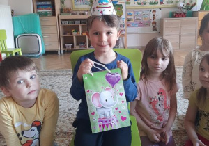 Kubuś pozuje z prezentem urodzinowym.
