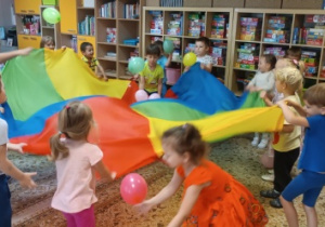 Zabawy z chustą i balonami.