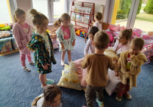 Dzieci układają wieżę z poduszek.