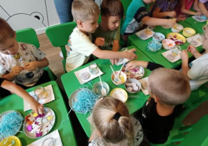 Warsztaty plastyczne - dzieci robią samodzielnie świeczniki.