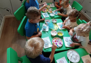 Warsztaty plastyczne - dzieci robią samodzielnie świeczniki.