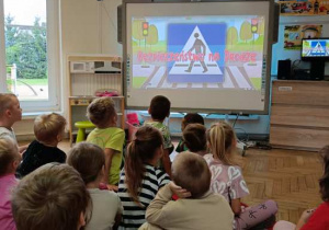 Dzieci oglądają film edukacyjny "Kazio i bezpieczeństwo na drodze".