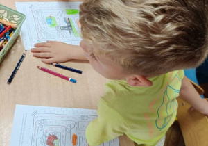 Dzieci wykonują kartę pracy dotyczącą bezpiecznej drogi z domu do przedszkola.