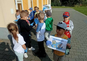 Dzieci sprzątają na terenie przedszkola.