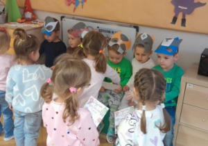 Dziewczynki wręczają chłopcom dyplomy super bohatera.
