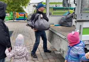 Dzieci i rodzice oddają surowce wtórne.