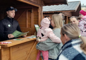 Dzieci z rodzicami uczestniczą w ekologicznej grze edukacyjnej.