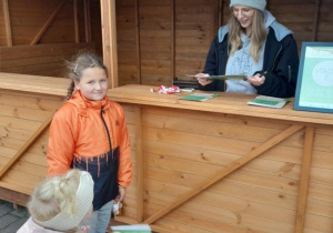 Dzieci z rodzicami uczestniczą w ekologicznej grze edukacyjnej.