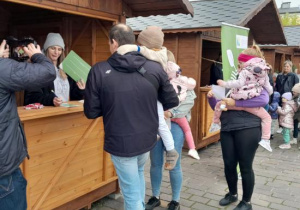 Dzieci z rodzicami uczestniczą w ekologicznej grze edukacyjnej.