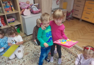 Dzieci wręczają laurki dla przyjaciela