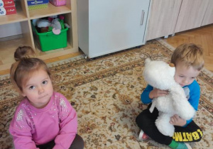 Dzieci dotykają miękkiego misia