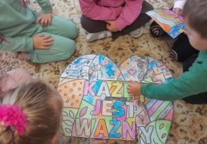 Dzieci składają pokolorowane serce w całość