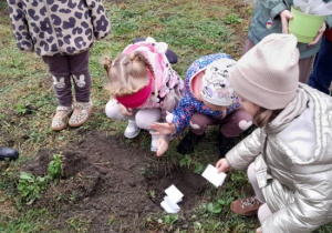 Dzieci zakopują swoje obietnice ekologiczne.
