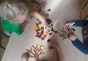 Dzieci dekorują filcowe drzewka.