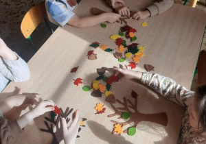Dzieci dekorują filcowe drzewka.