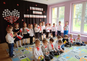 Dzieci prezentują instrumentalizację piosenki patriotycznej.
