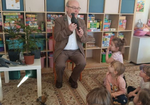 Dzieci słuchają ciekawostek o ptakach występujących w lasach.