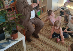 Dzieci słuchają ciekawostek o ptakach występujących w lasach.