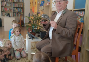 Dzieci słuchają ciekawostek o ptakach występujących w lasach.