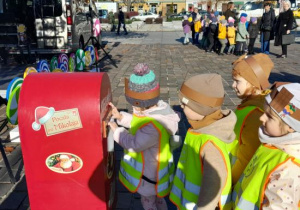 Dzieci wrzucają list do skrzynki.