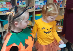 Rodzice i dzieci uczestniczą w zabawach ruchowych z dynią.