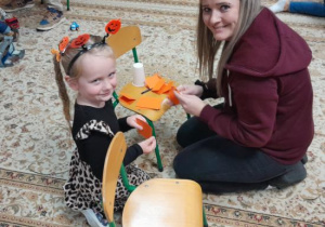 Rodzice i dzieci tworzą papierowe dynie.