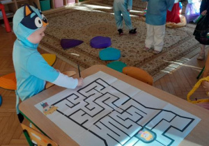 Chłopiec rysuje drogę w labiryncie.